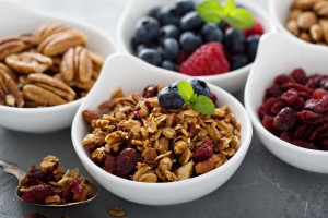 Variety of breakfast food with nuts and granola in small bowls