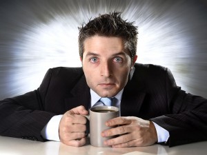young addict businessman in suit and tie holding cup of coffee anxious and crazy in caffeine addiction and need to keep awaken on zoom effect grunge background
